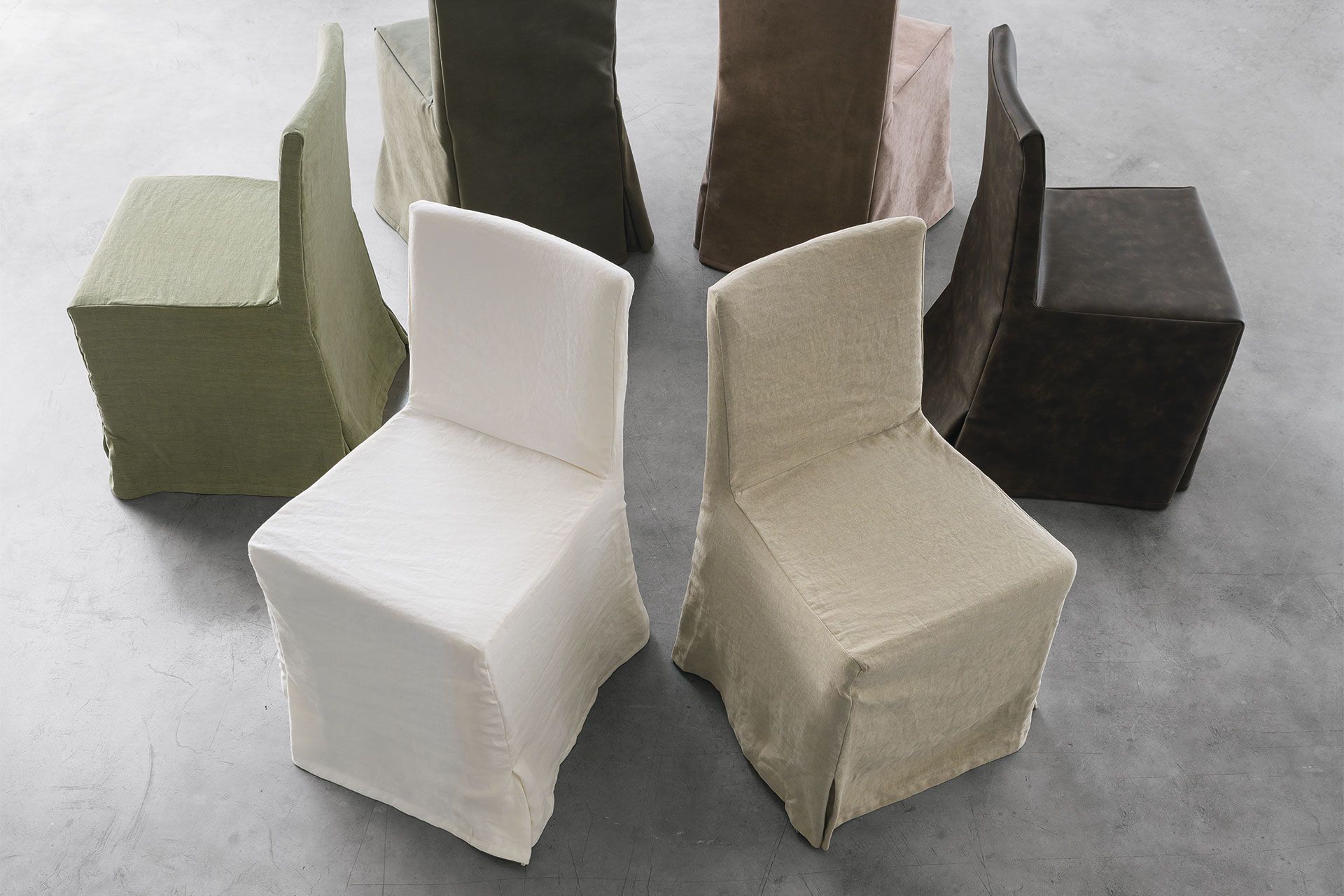 Un gruppo di sedie di diversi colori sono disposte in cerchio