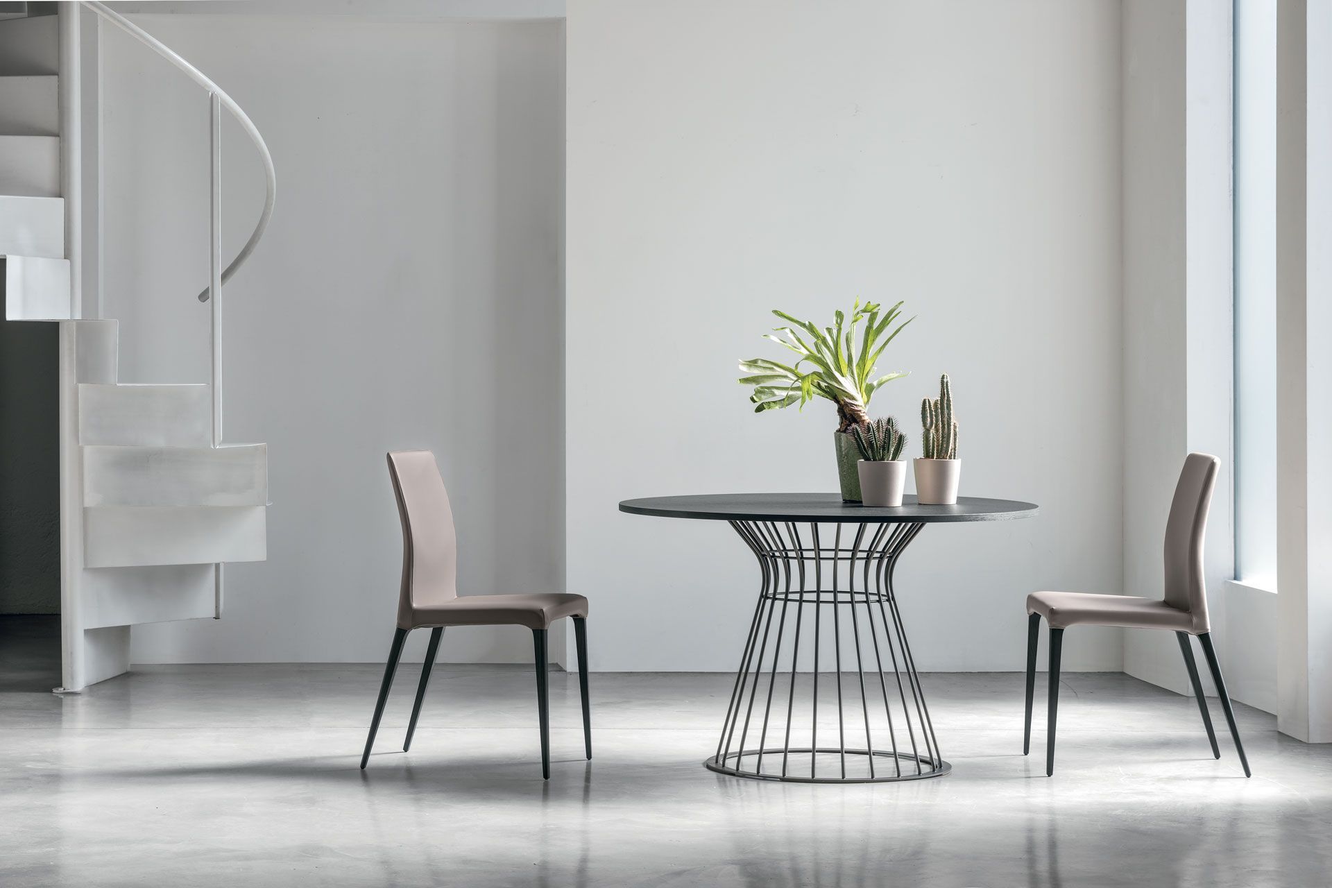 Un tavolo e delle sedie in una stanza con una scala a chiocciola