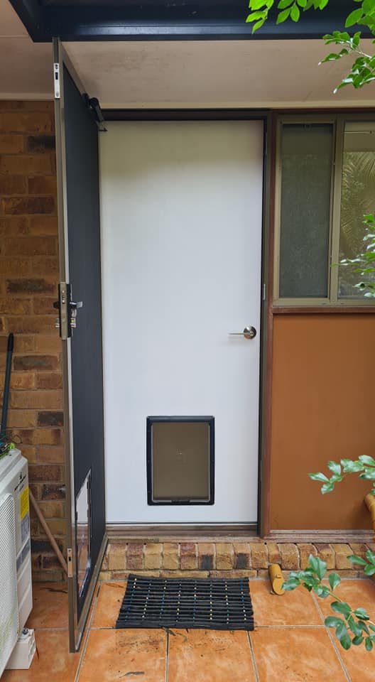 A White Door with Small Dog Door — Quality Custom Screens in Caloundra, QLD