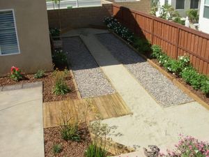 A driveway leading to a house with a wooden fence