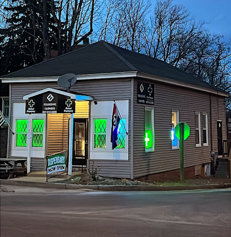A grey building at dusk with a lighted 