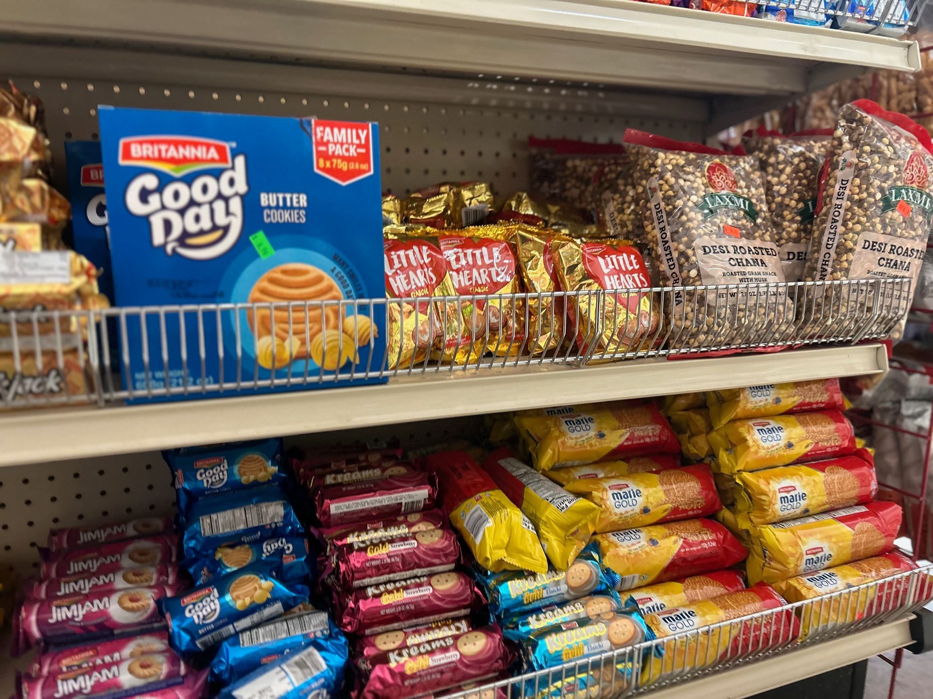 A shelf filled with lots of snacks including a box of good day cookies.