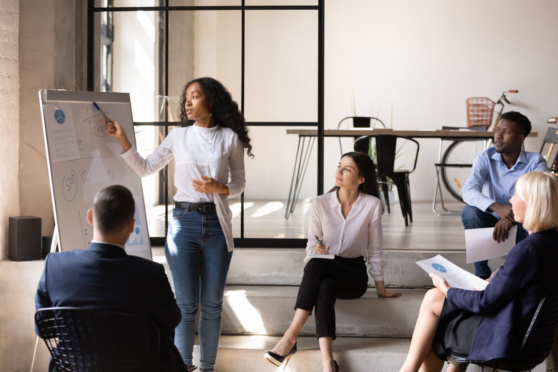 A woman is giving a presentation to a group of people.