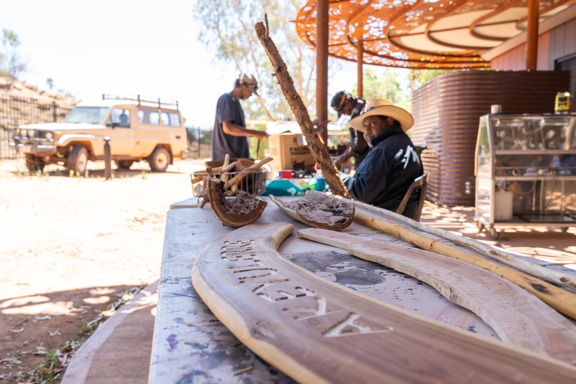 A group of men are working on a piece of wood.