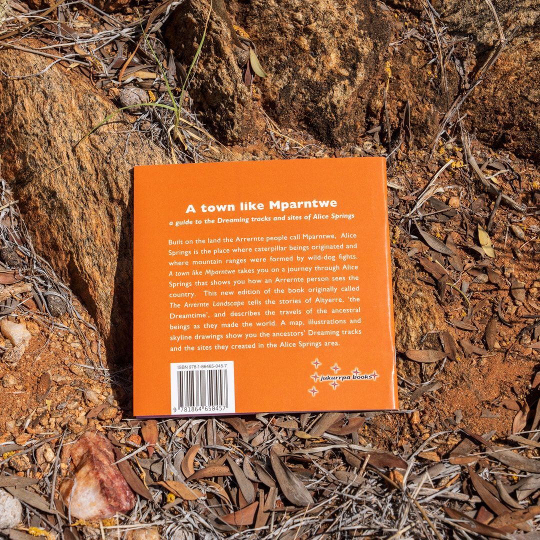 A book titled a town like mparatwe is laying on the ground