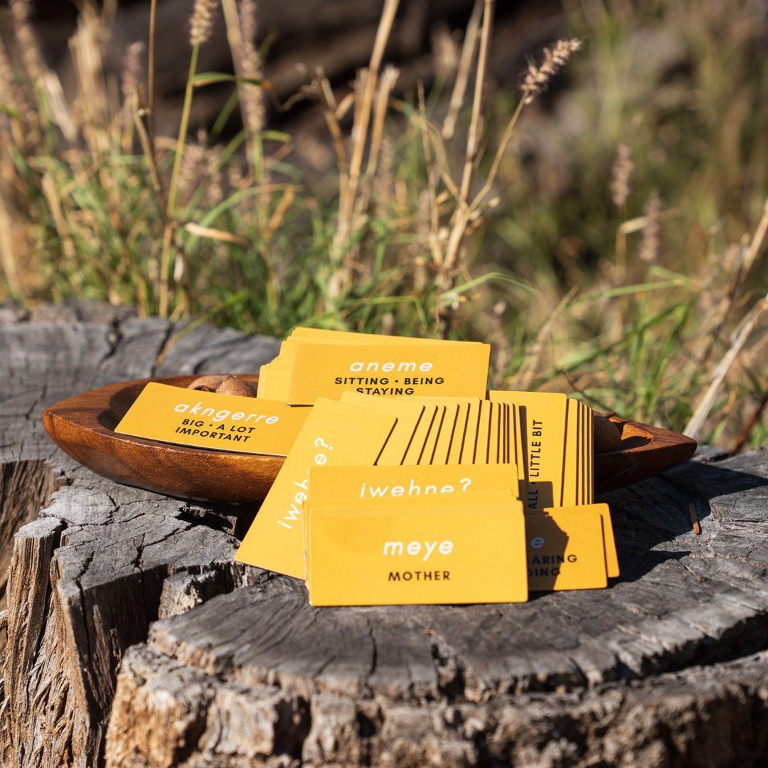 A stack of yellow business cards sitting on top of a tree stump