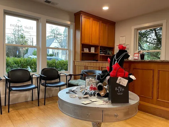 Waiting room with black chairs, wood cabinets, and a holiday-decorated round table with a black Santa bag.