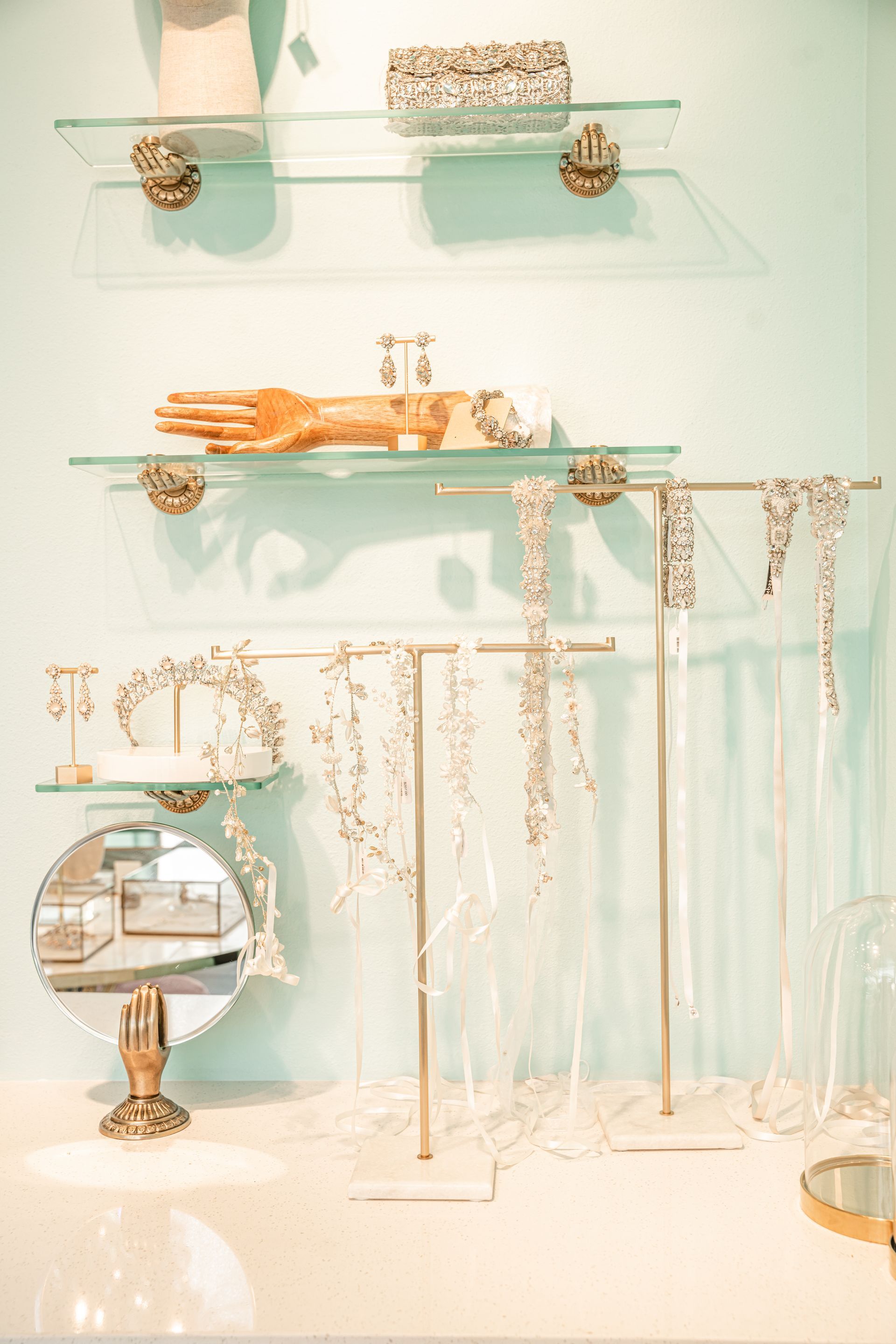A display of jewelry in a store with shelves and a mirror.