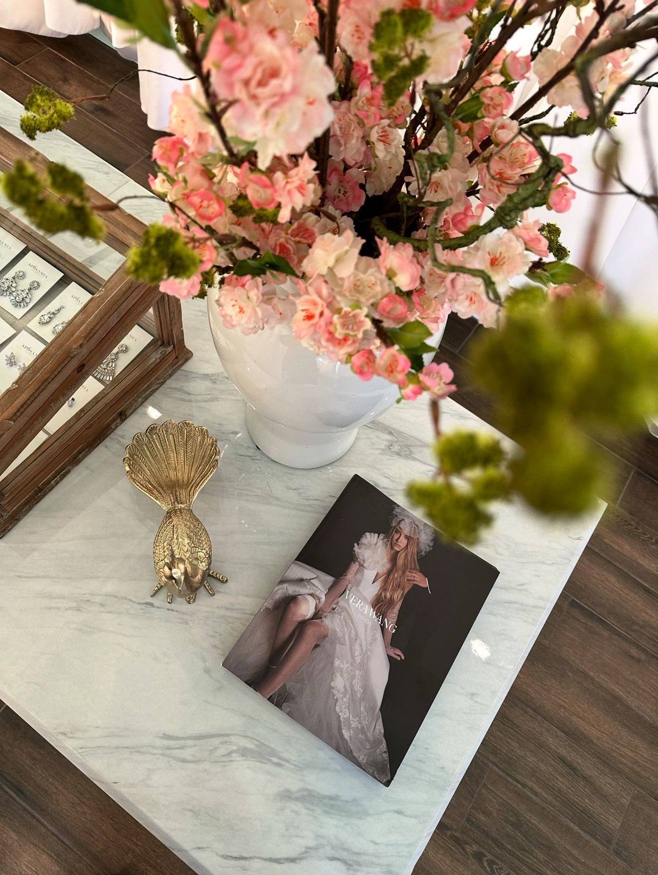A vase of flowers is sitting on a table next to a picture of a woman in a wedding dress.