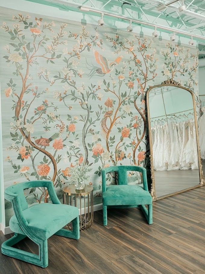 There are two chairs and a large mirror in the room.