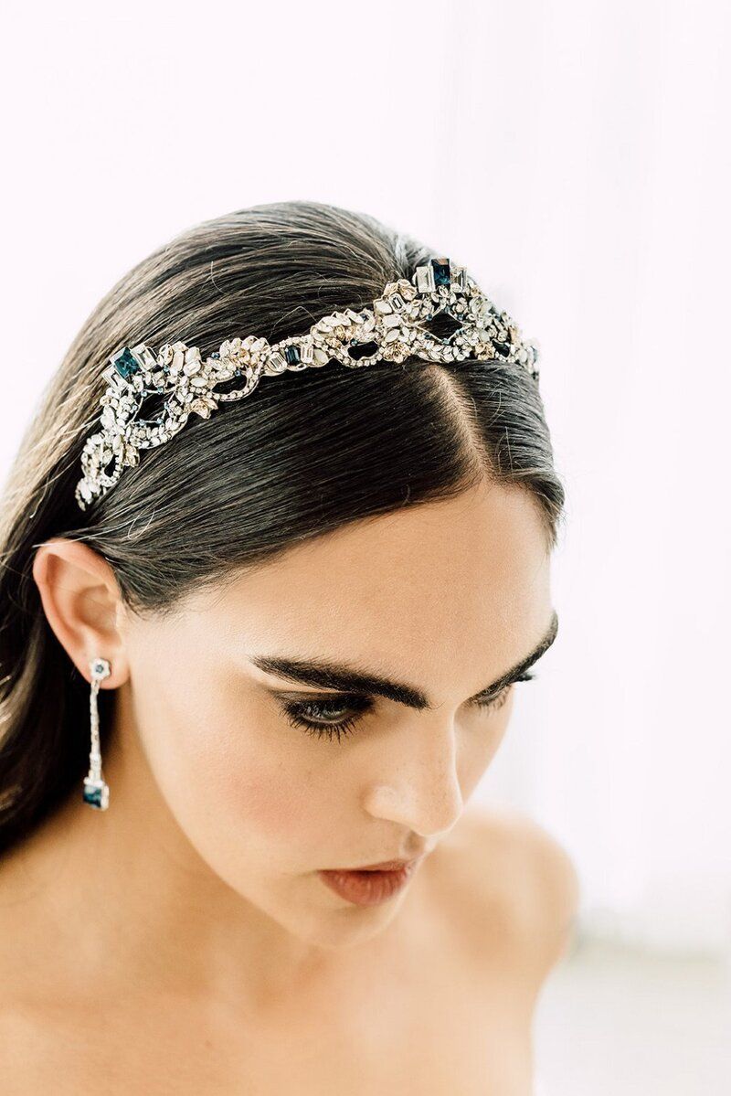 A close up of a woman wearing a headband and earrings.
