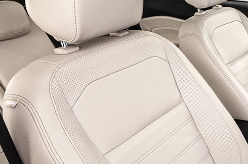 Um close de um assento de couro branco em um carro.