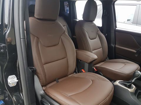 O interior de um jipe renegade com bancos de couro marrom.