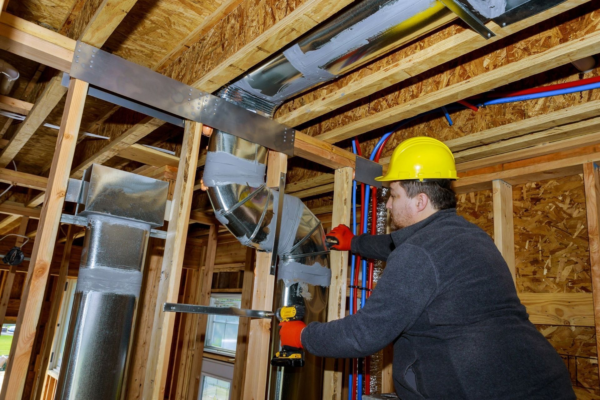 HVAC technician wearing mask and hard hat, working on AC units on a rooftop. HVAC technician wearing mask and hard hat, working on AC units on a rooftop.