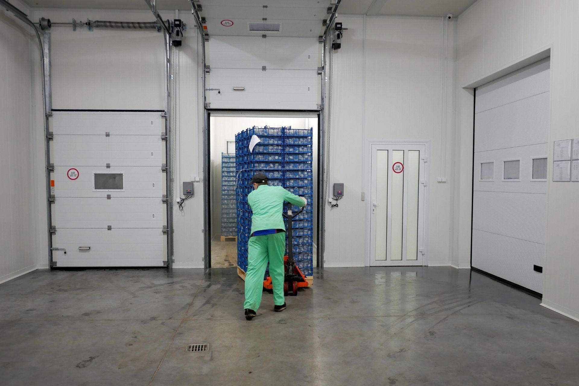 HVAC technician wearing mask and hard hat, working on AC units on a rooftop.