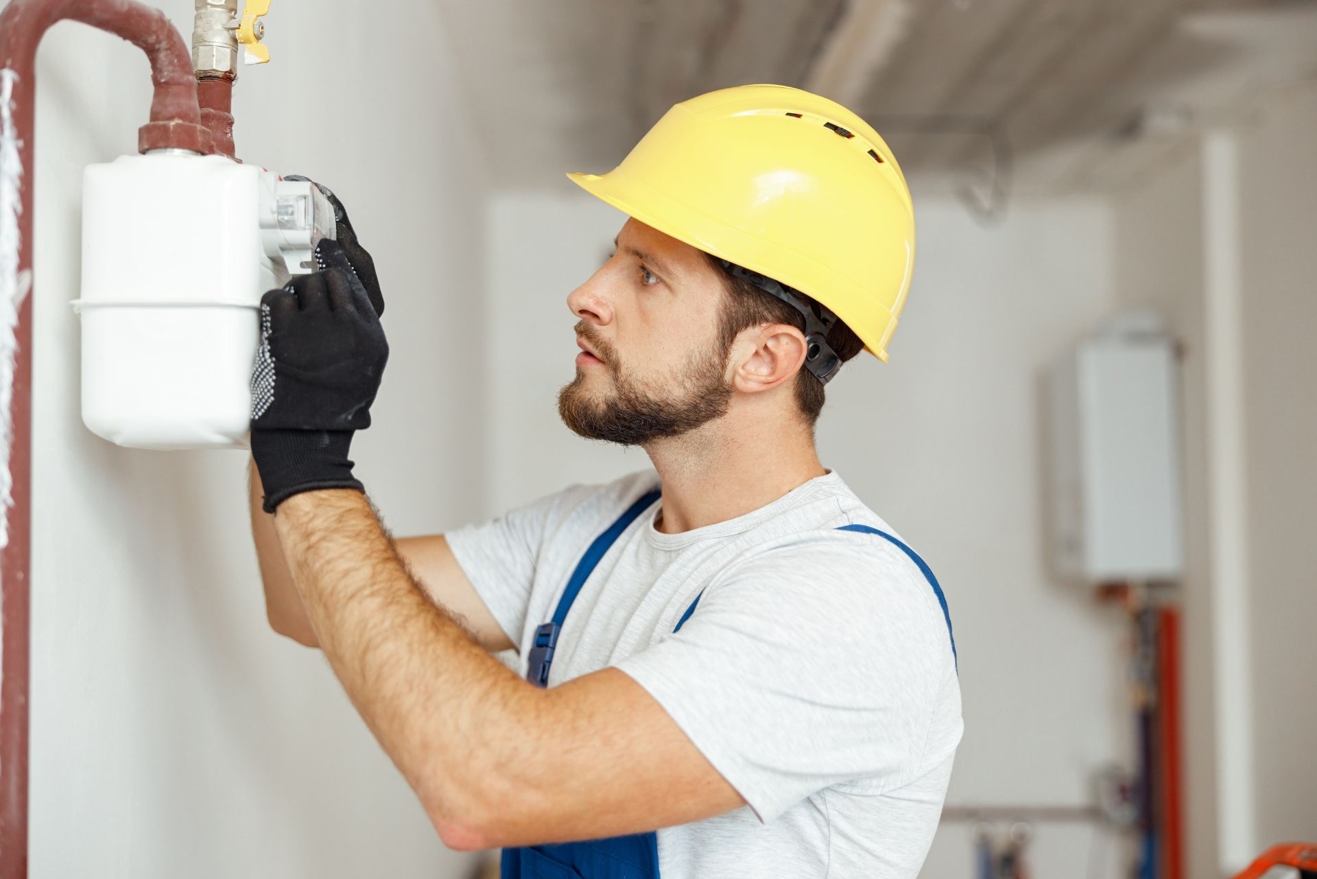 HVAC technician wearing mask and hard hat, working on AC units on a rooftop.