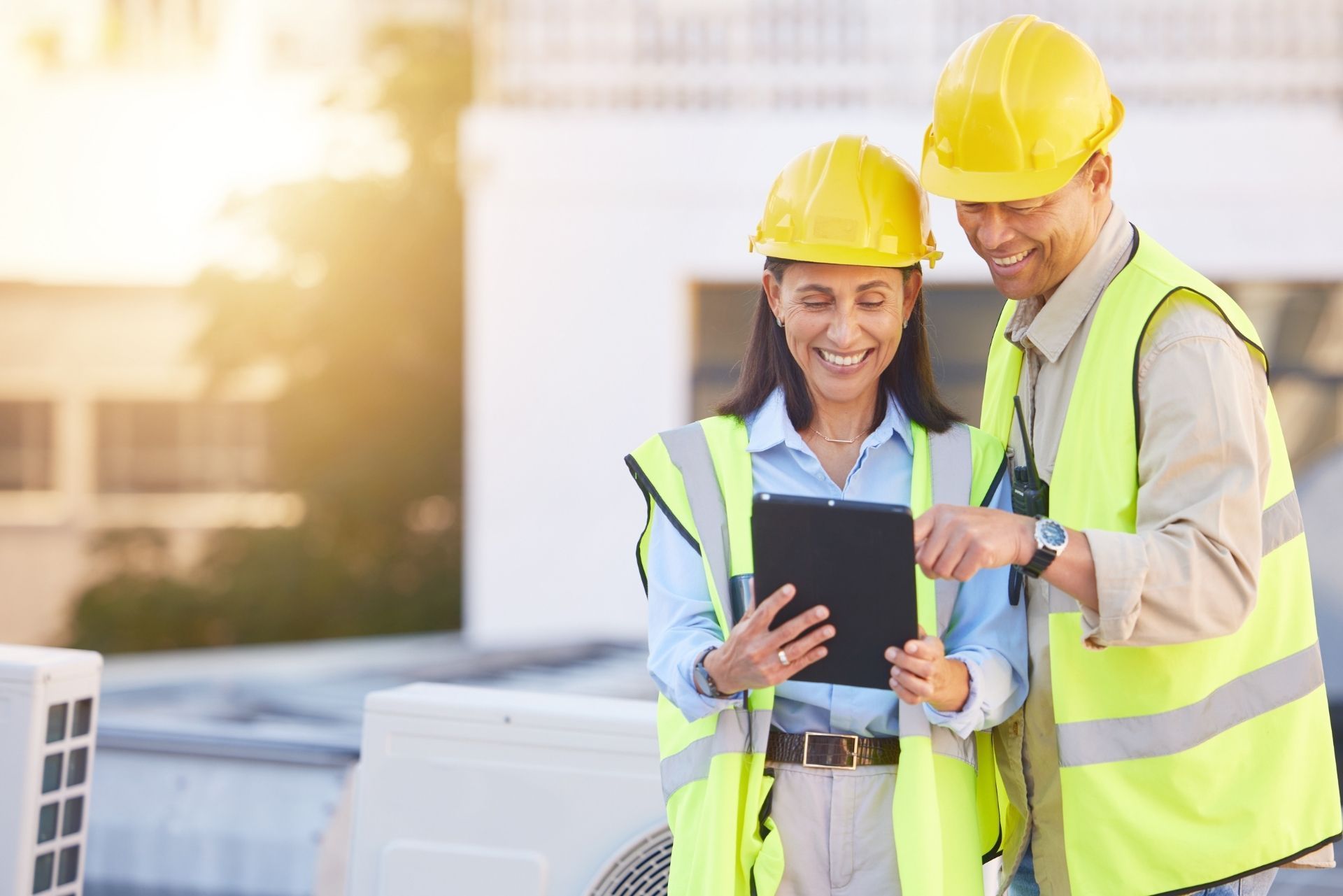 HVAC technician wearing mask and hard hat, working on AC units on a rooftop. HVAC technician wearing mask and hard hat, working on AC units on a rooftop.