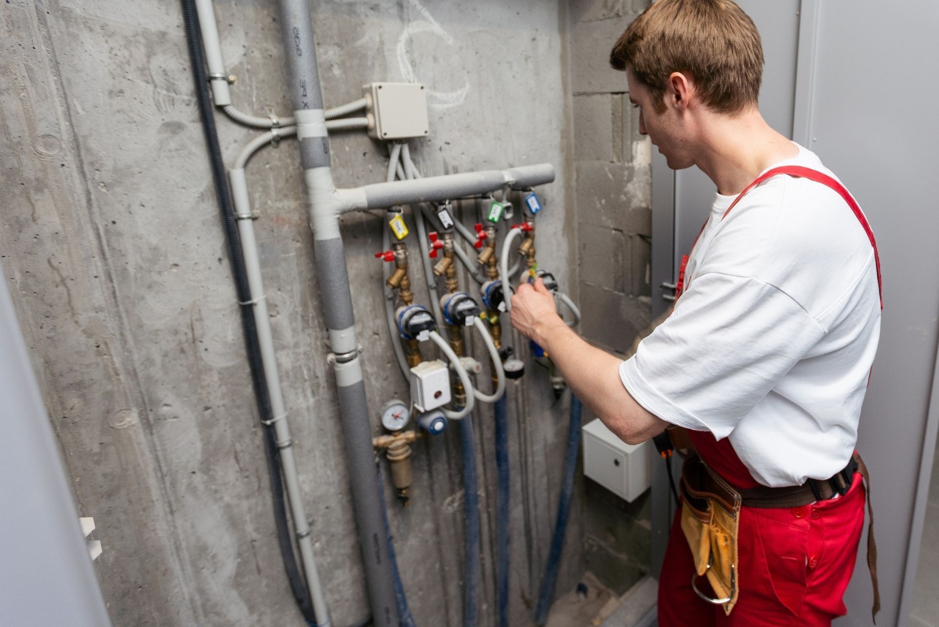 HVAC technician wearing mask and hard hat, working on AC units on a rooftop. HVAC technician wearing mask and hard hat, working on AC units on a rooftop.