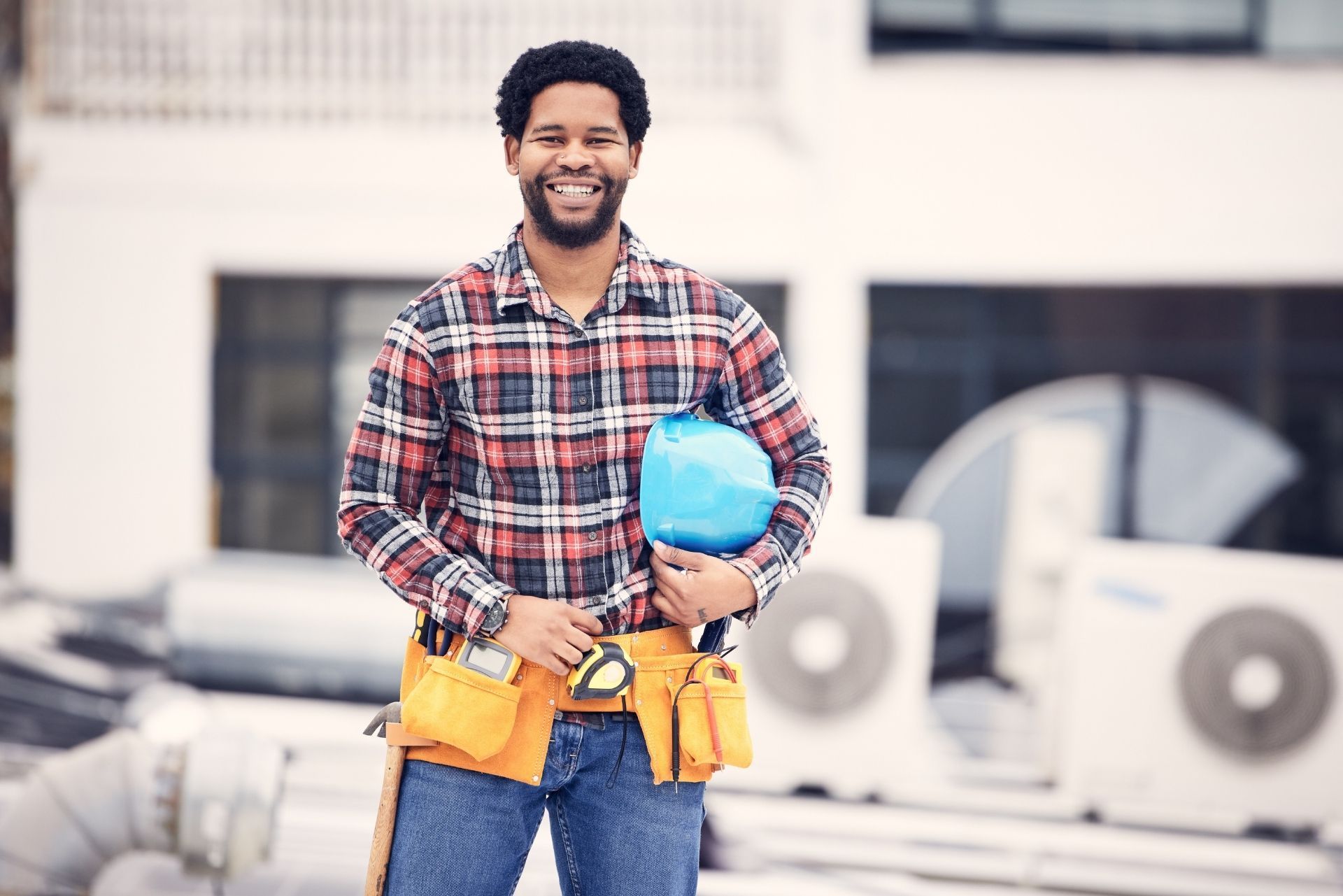 HVAC technician wearing mask and hard hat, working on AC units on a rooftop. HVAC technician wearing mask and hard hat, working on AC units on a rooftop.