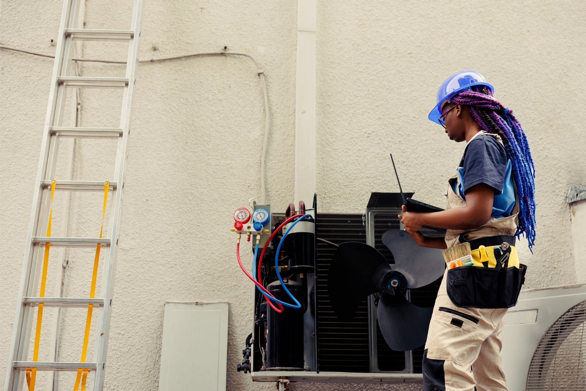 HVAC technician wearing mask and hard hat, working on AC units on a rooftop. HVAC technician wearing mask and hard hat, working on AC units on a rooftop.