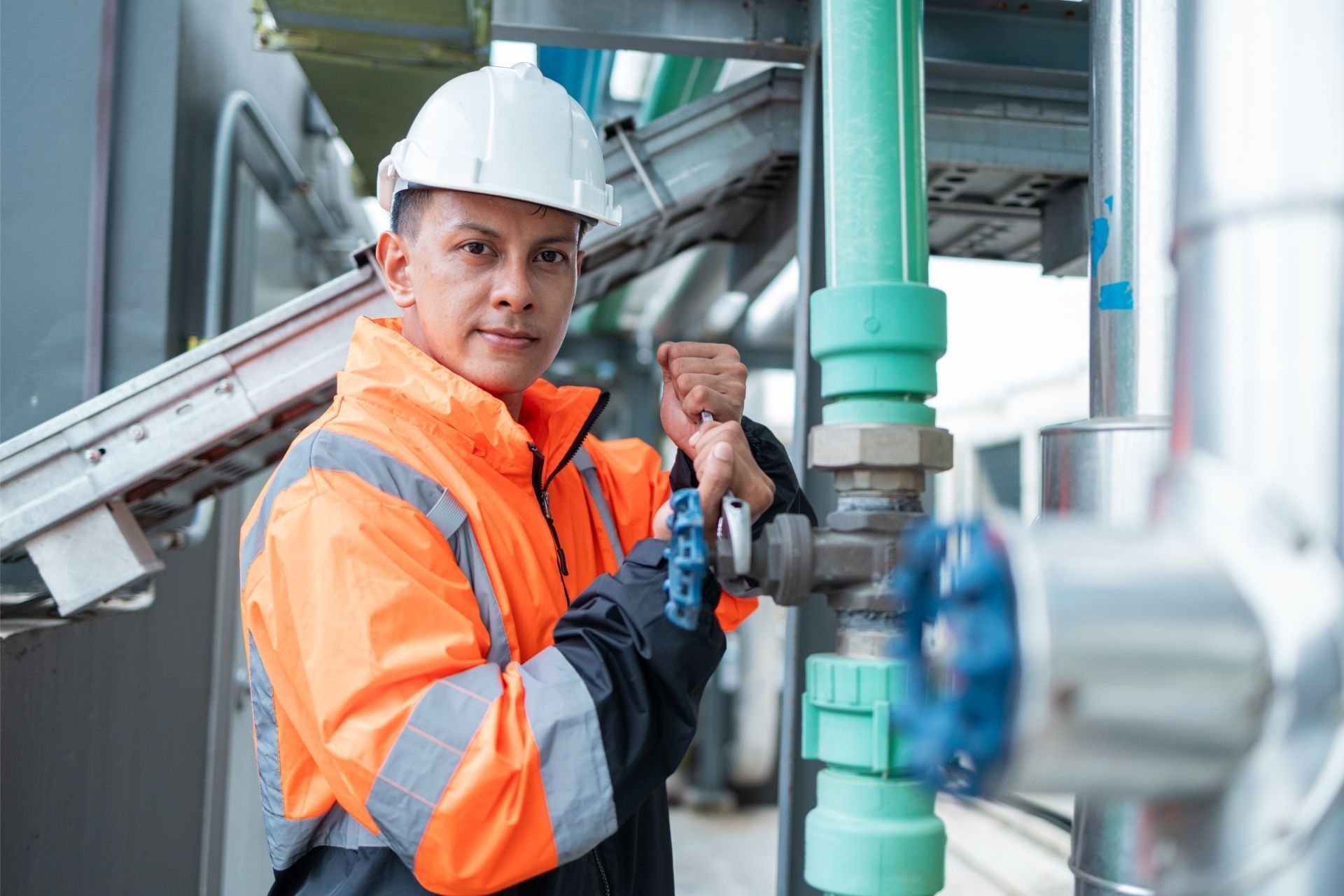 HVAC technician wearing mask and hard hat, working on AC units on a rooftop. HVAC technician wearing mask and hard hat, working on AC units on a rooftop.