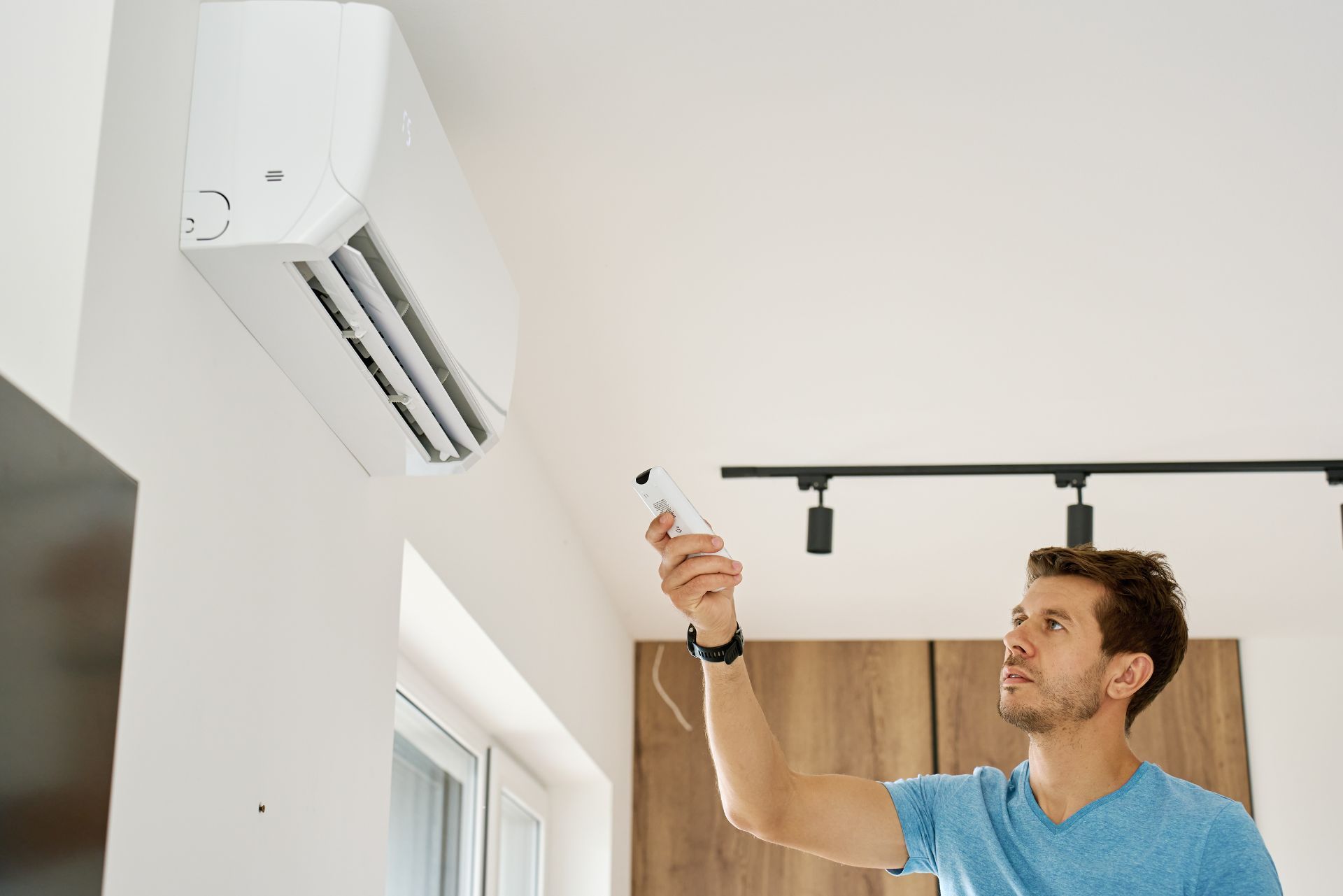 HVAC technician wearing mask and hard hat, working on AC units on a rooftop. HVAC technician wearing mask and hard hat, working on AC units on a rooftop.