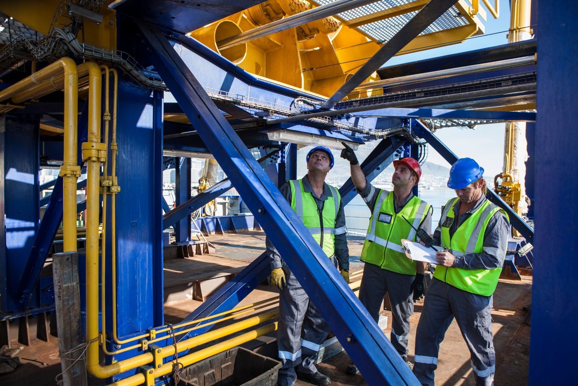 HVAC technician wearing mask and hard hat, working on AC units on a rooftop. HVAC technician wearing mask and hard hat, working on AC units on a rooftop.