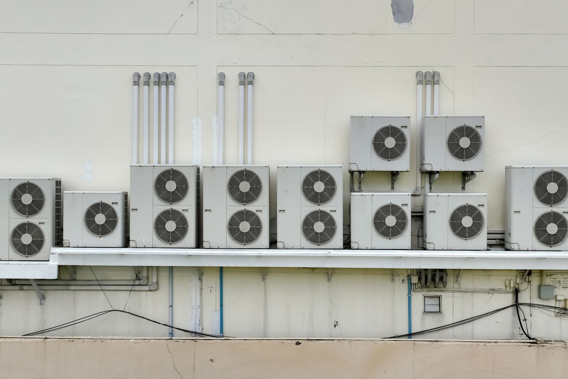HVAC technician wearing mask and hard hat, working on AC units on a rooftop. HVAC technician wearing mask and hard hat, working on AC units on a rooftop.