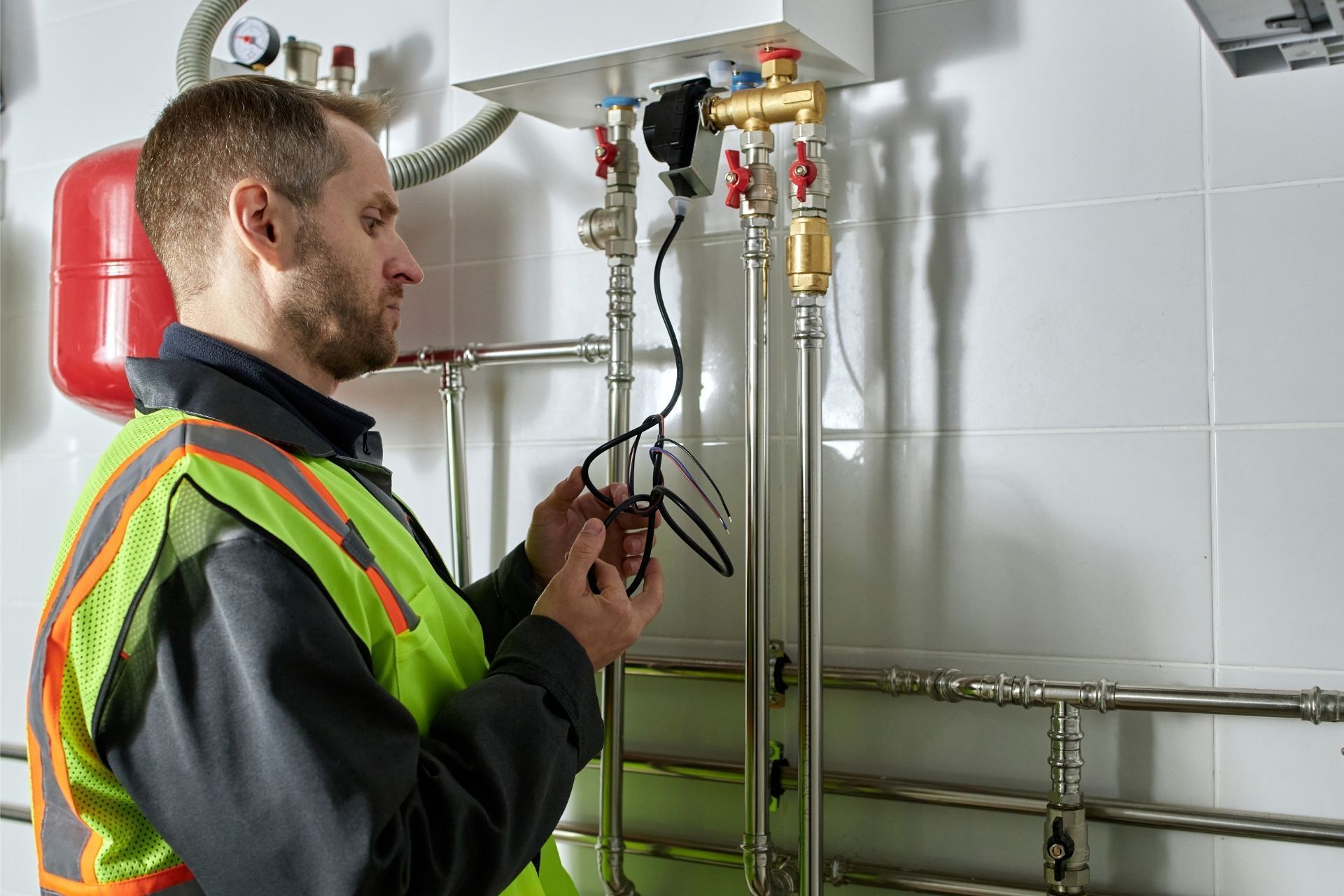 HVAC technician wearing mask and hard hat, working on AC units on a rooftop. HVAC technician wearing mask and hard hat, working on AC units on a rooftop.