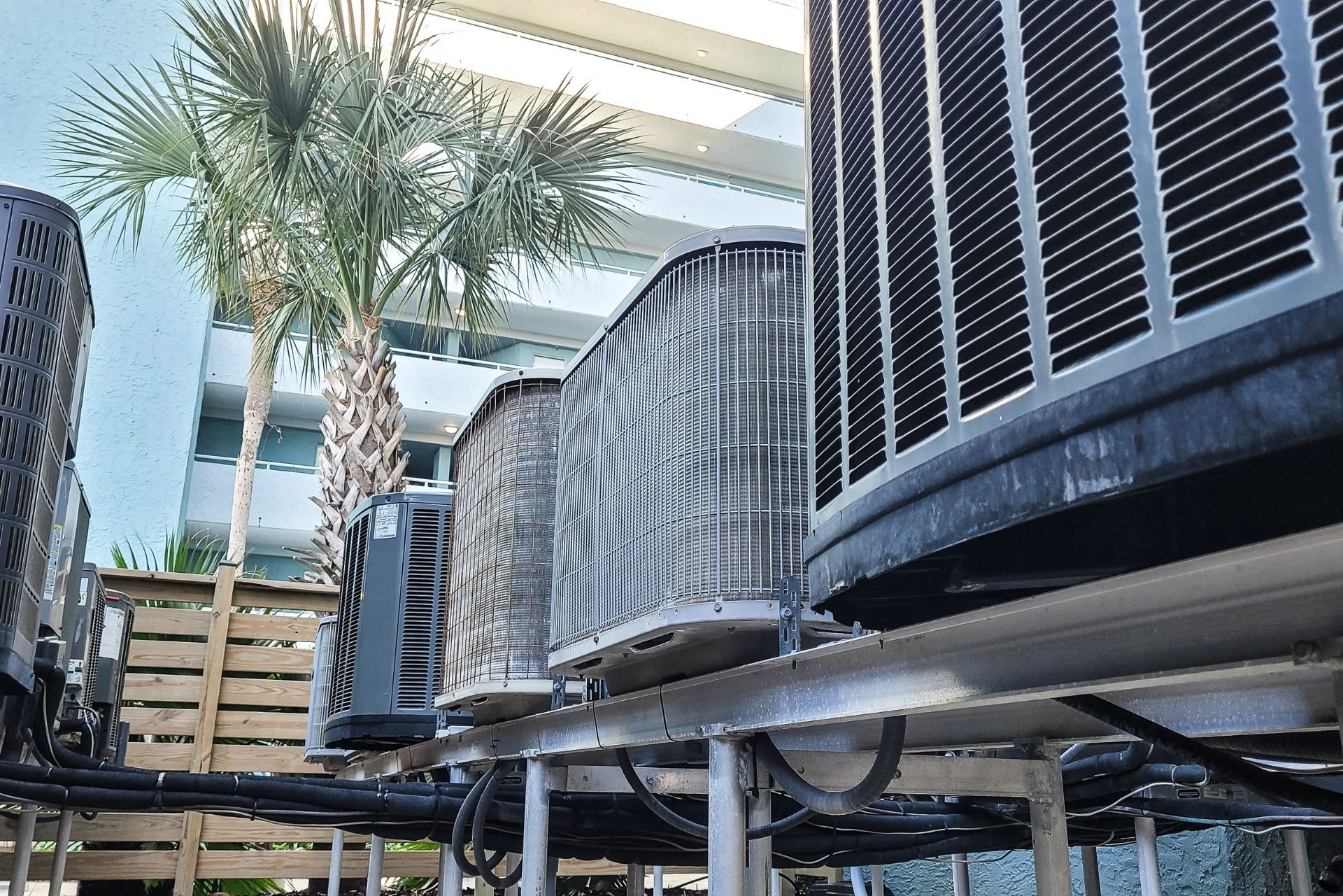 HVAC technician wearing mask and hard hat, working on AC units on a rooftop. HVAC technician wearing mask and hard hat, working on AC units on a rooftop.
