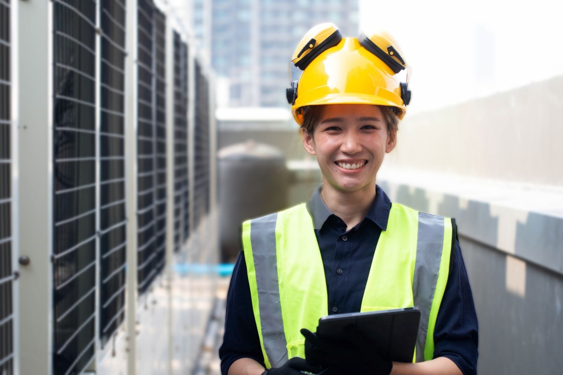 HVAC technician wearing mask and hard hat, working on AC units on a rooftop. HVAC technician wearing mask and hard hat, working on AC units on a rooftop.