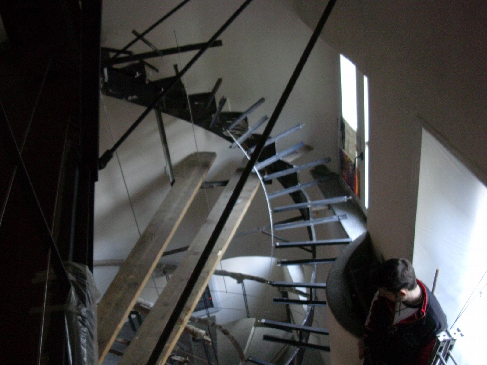 Una persona in piedi in una stanza buia con una scala sullo sfondo