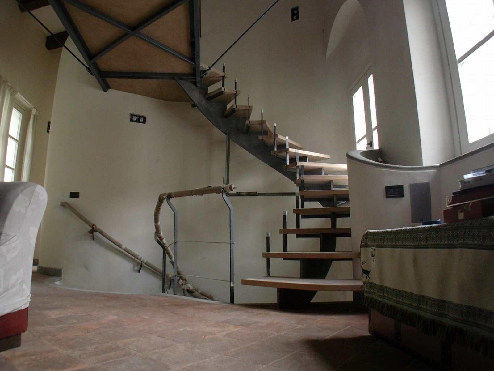 Una scala a chiocciola in una stanza con una sedia e un tavolo