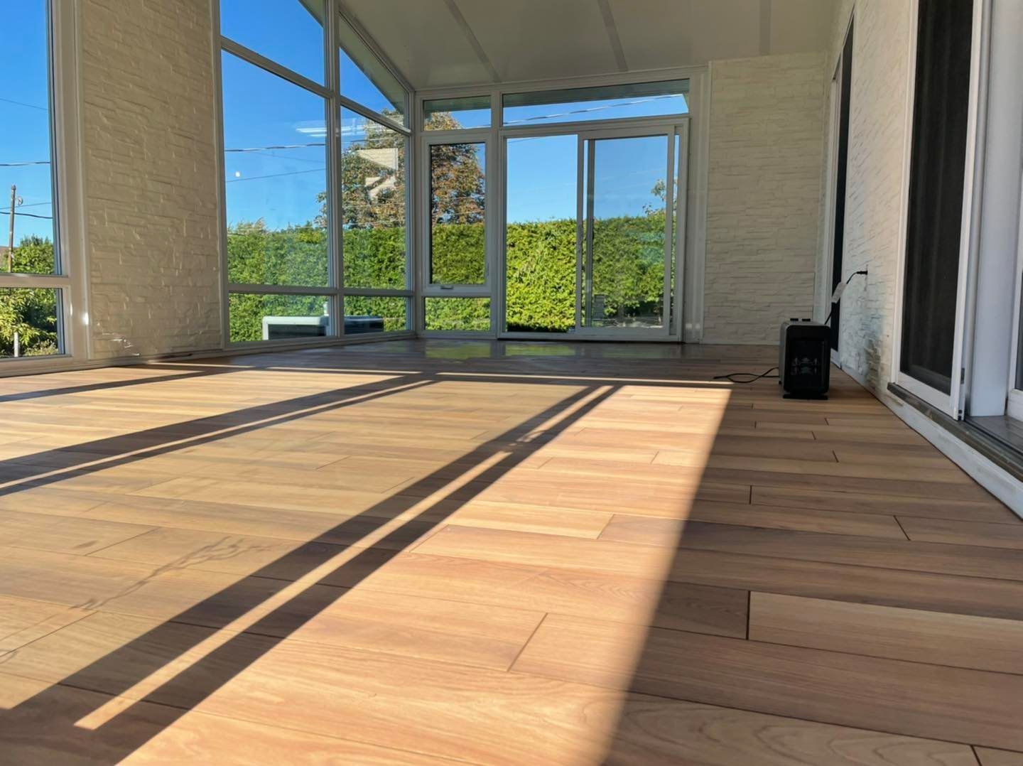 Une pièce vide avec du parquet et de nombreuses fenêtres.