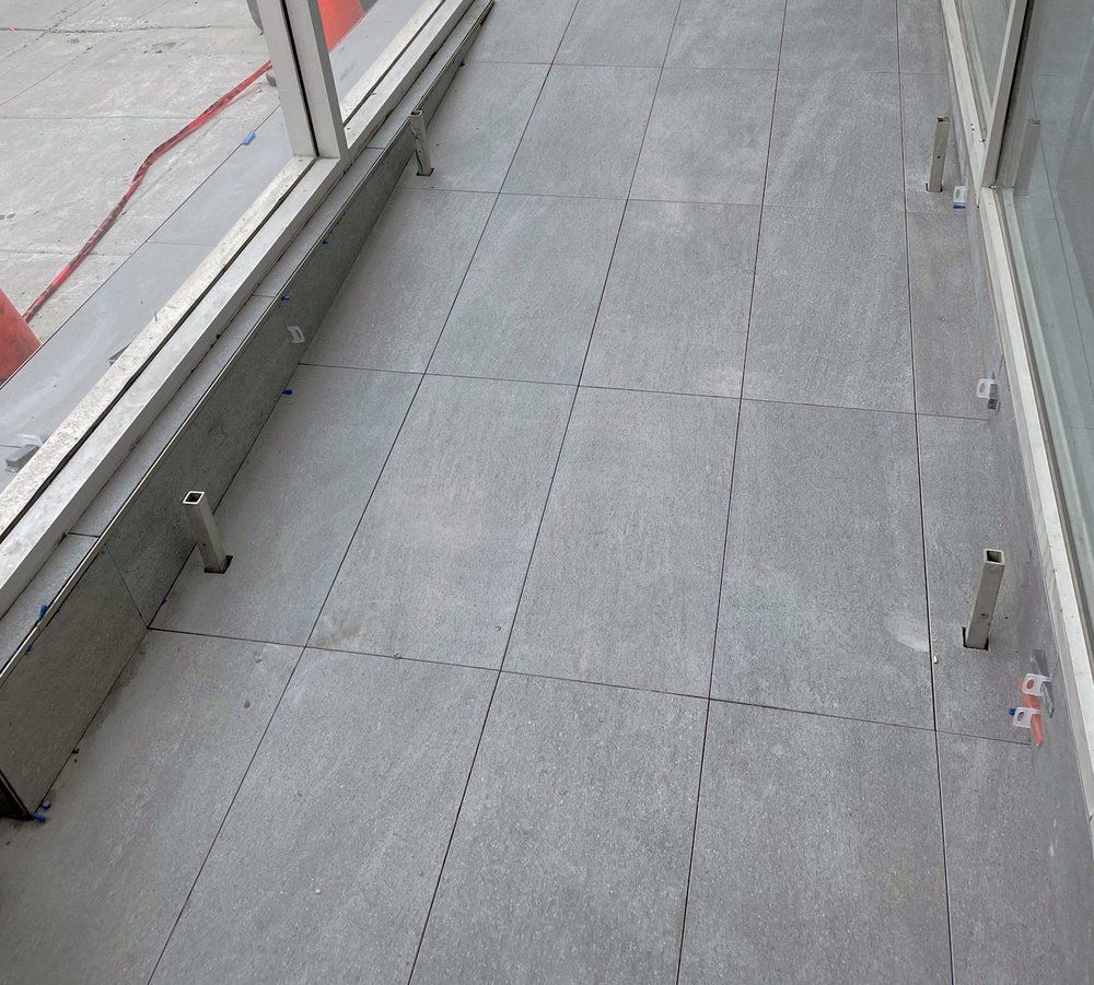 Un sol carrelé gris avec une fenêtre en arrière-plan