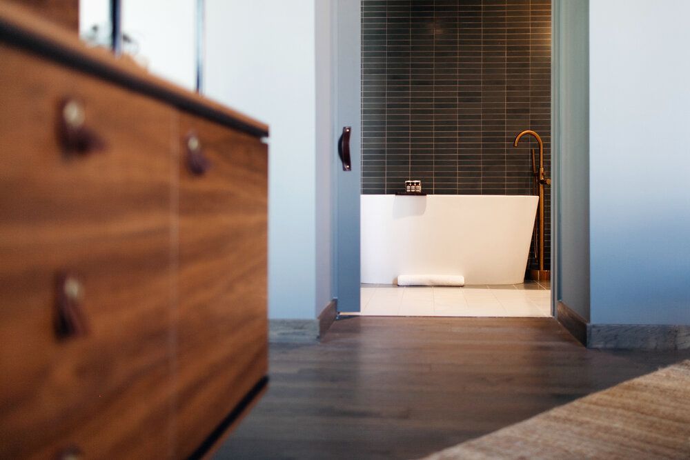 Une salle de bain avec baignoire, lavabo et armoires en bois.