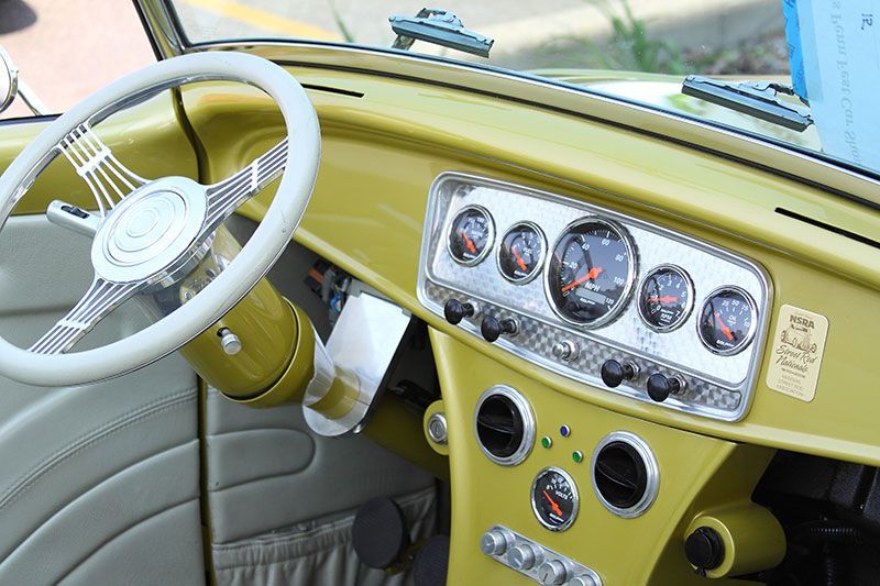 A yellow car with a steering wheel and dashboard.