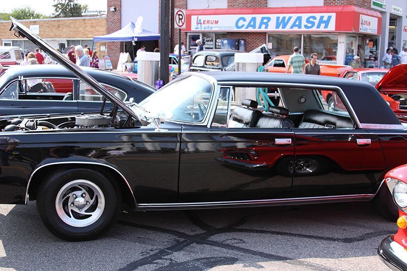A black car is parked in front of a car wash.