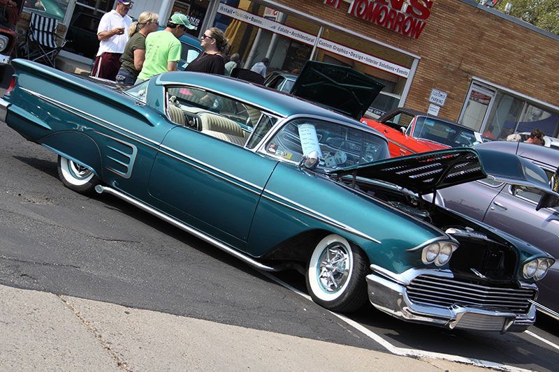 A blue car is parked in front of a building.
