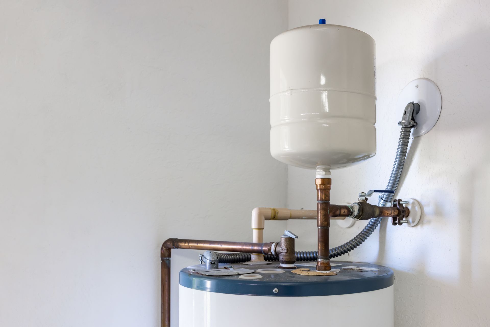 A water heater is mounted to the wall in a room.