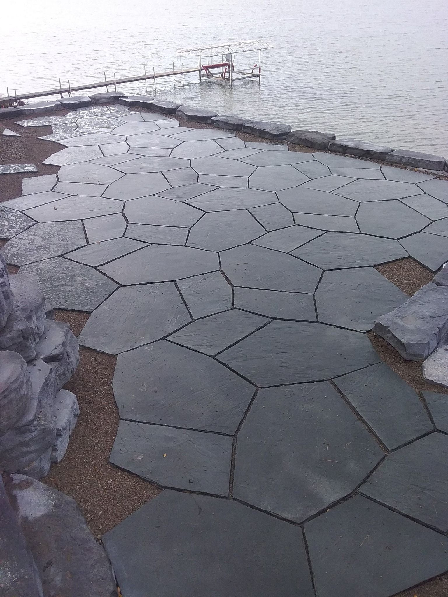 A stone walkway leading to a body of water.