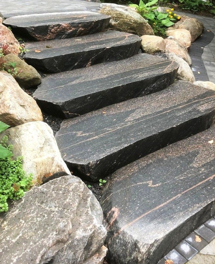 A set of stone stairs surrounded by rocks in a garden.