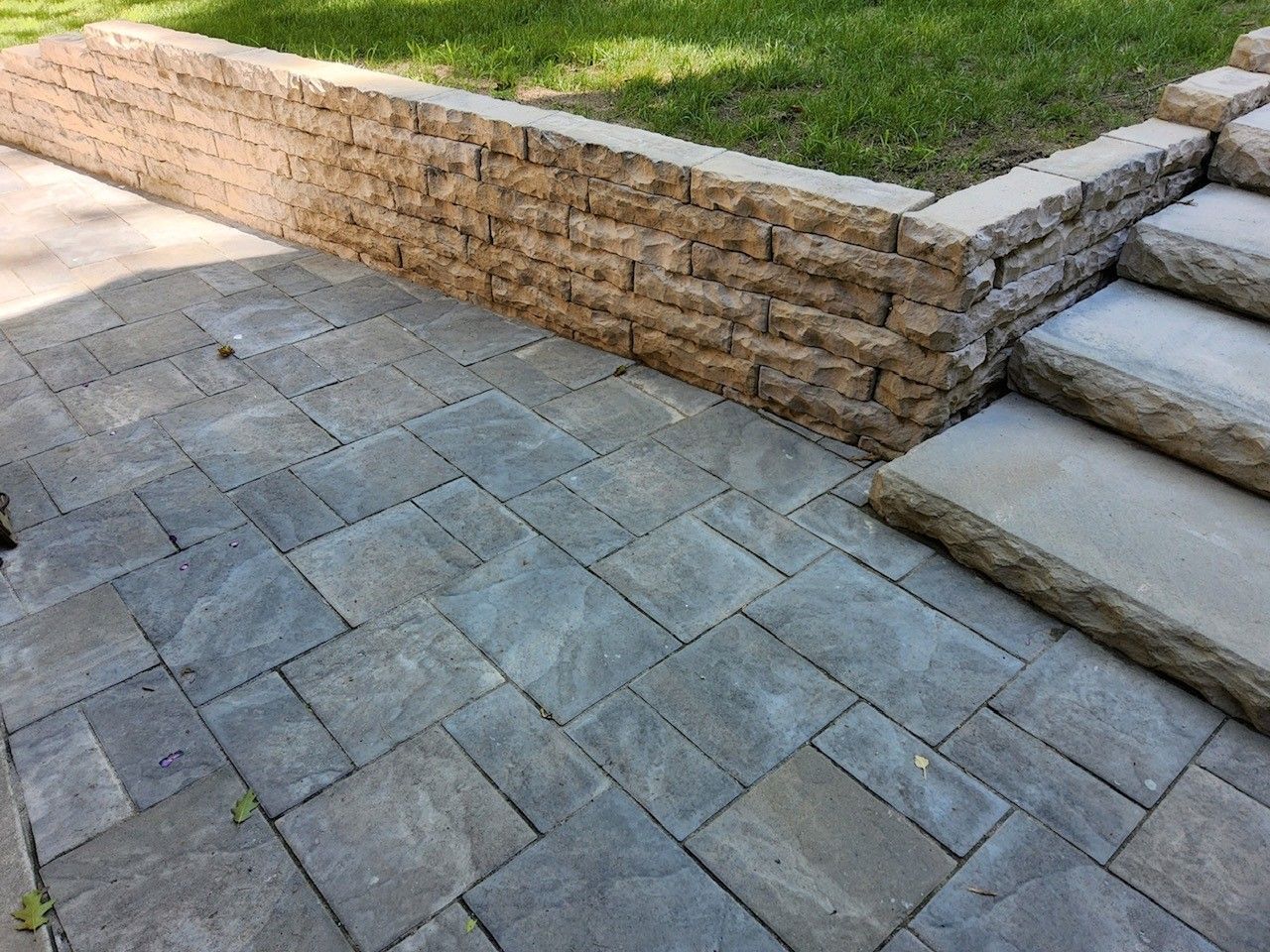 A stone walkway with stairs and a stone wall.
