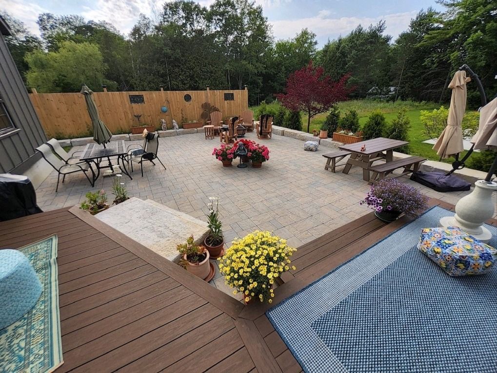 A large patio with a table and chairs and a fire pit.
