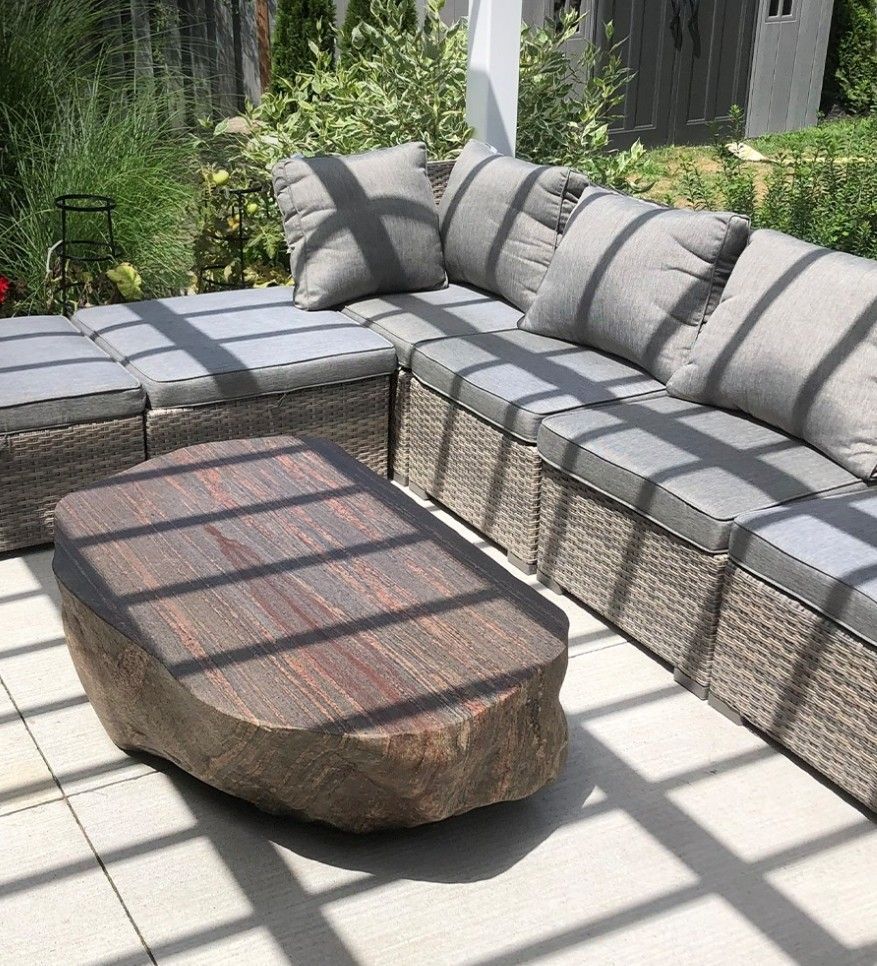 A patio with a couch and a coffee table under a pergola