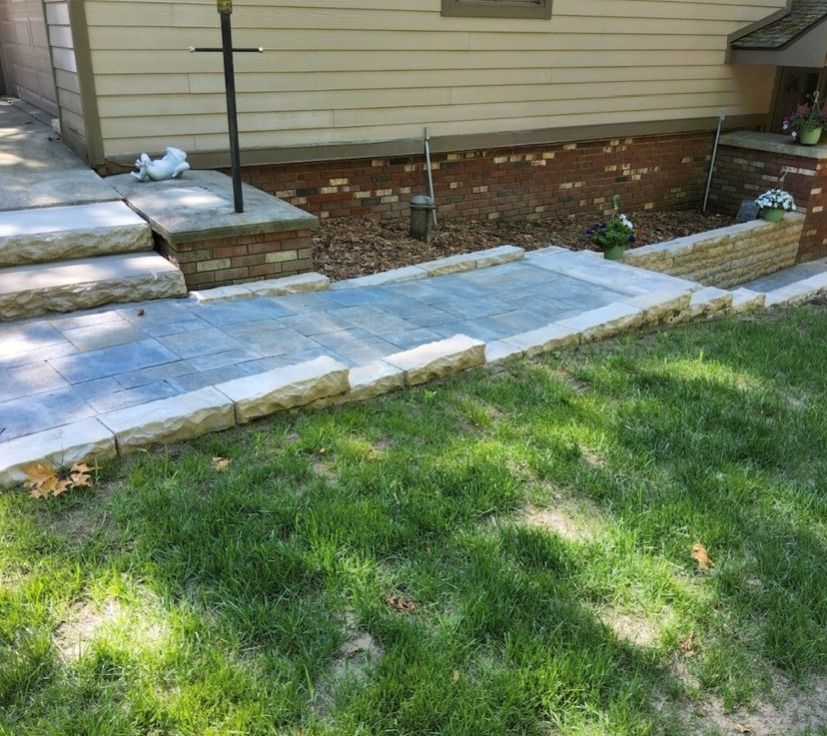A stone walkway leading to a house with steps