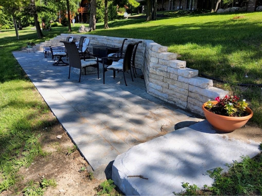 A patio with a table and chairs and a potted plant.