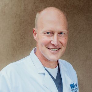 a man wearing a white lab coat with the word pro on it