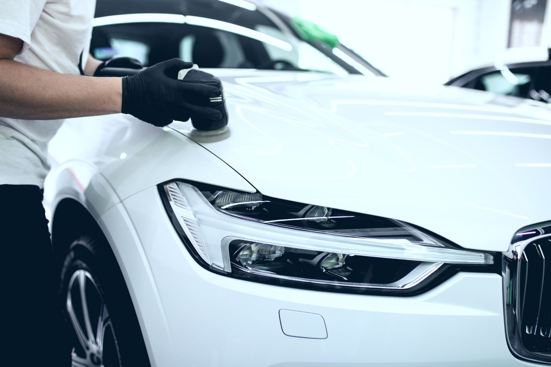 carrozziere in officina durante la lucidatura di una vettura