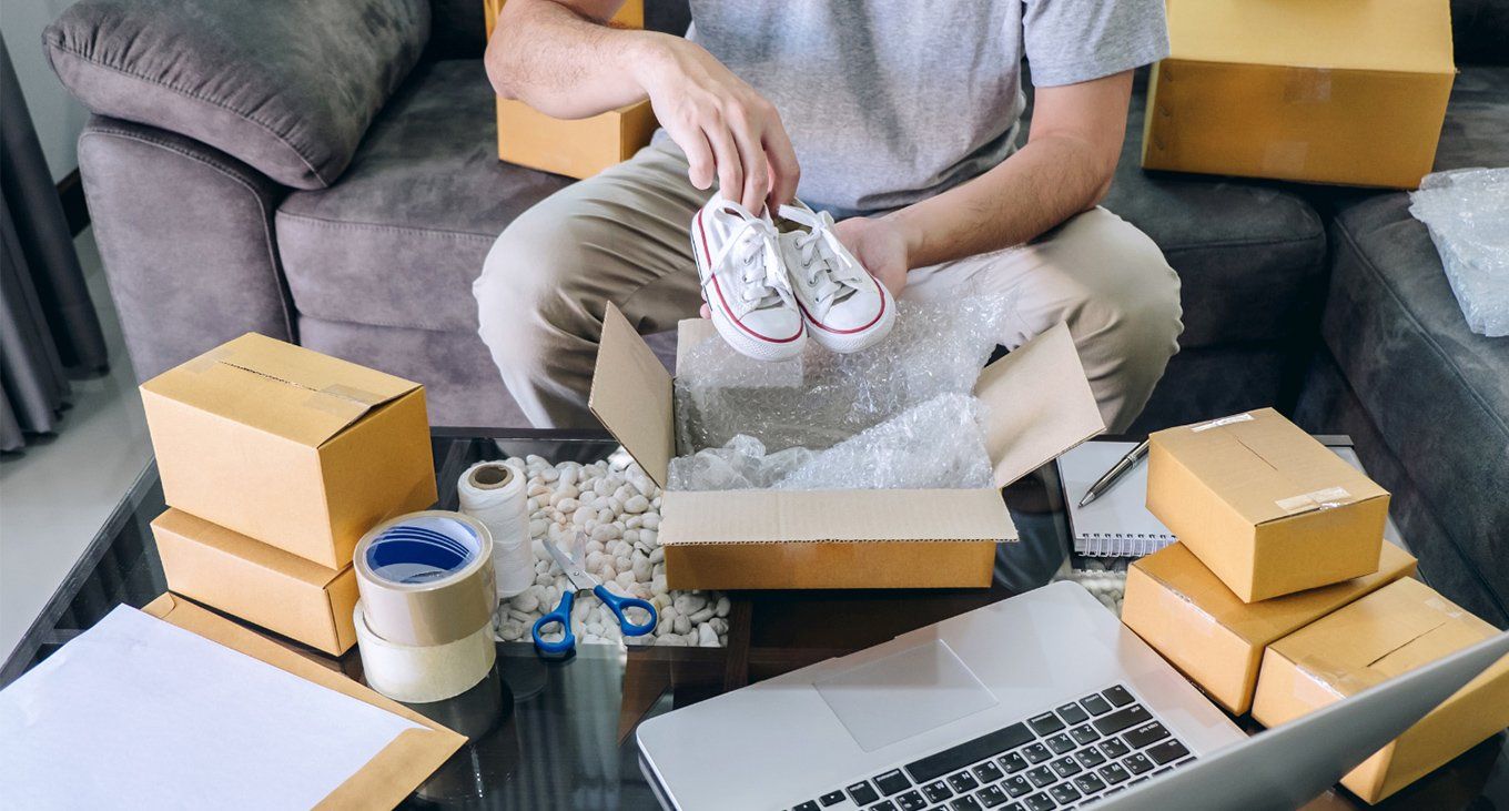 A homeowner packing shoes for online selling
